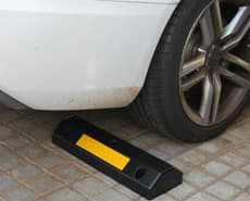 Silver plastic wheel stop for vehicles installed